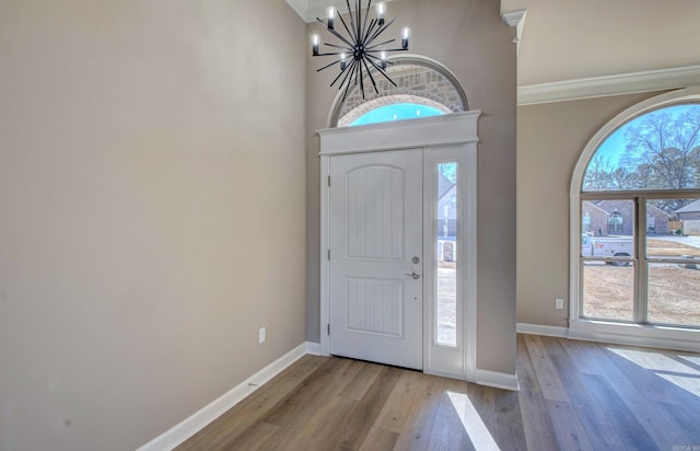 entrance foyer with a chandelier, wood-type flooring, and plenty of natural light