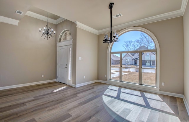 unfurnished dining area featuring a chandelier, visible vents, and wood finished floors