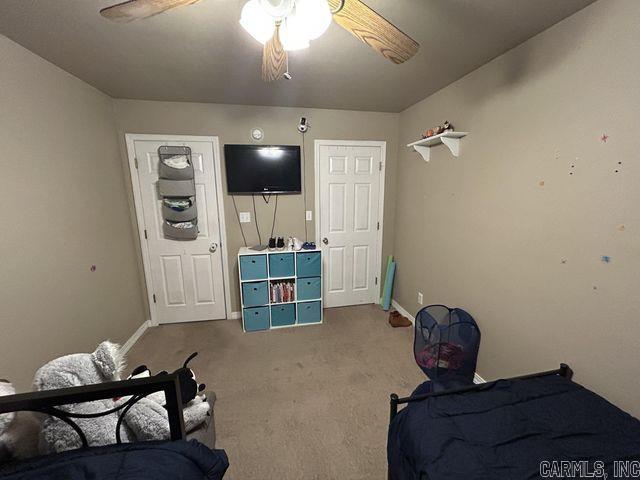 rec room with carpet, a ceiling fan, and baseboards