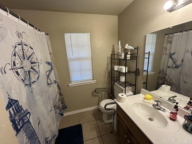 full bathroom featuring tile patterned flooring, baseboards, vanity, and toilet