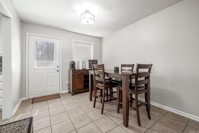 dining space with light tile patterned floors and baseboards