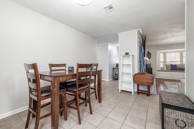 dining area with light tile patterned flooring, visible vents, and baseboards