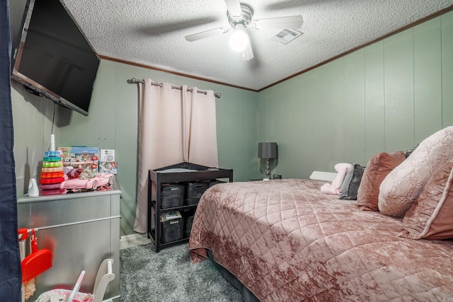 bedroom with a textured ceiling, ceiling fan, carpet flooring, visible vents, and crown molding