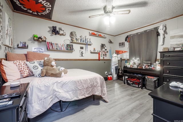 bedroom with a ceiling fan, crown molding, light wood-style flooring, and a textured ceiling