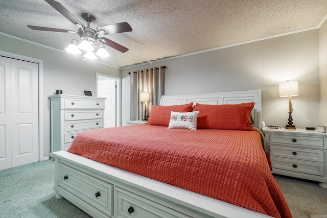 carpeted bedroom featuring a textured ceiling, ornamental molding, and a closet