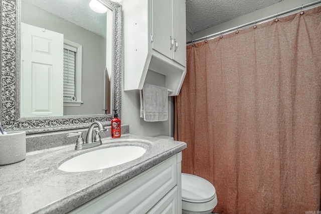 full bath featuring a textured ceiling, vanity, and toilet