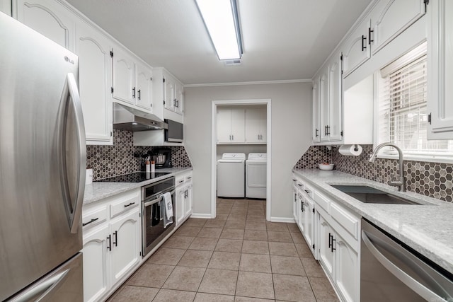 kitchen featuring white cabinets, independent washer and dryer, stainless steel appliances, under cabinet range hood, and a sink