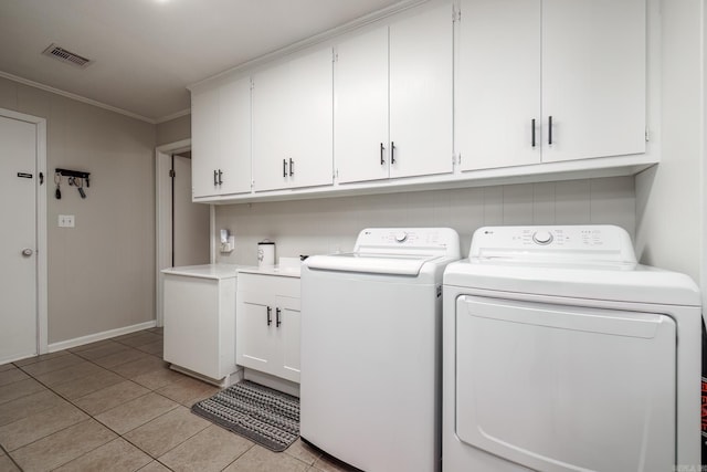 washroom with light tile patterned floors, visible vents, cabinet space, ornamental molding, and separate washer and dryer