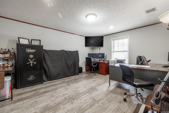 office space featuring crown molding, a textured ceiling, visible vents, and wood finished floors