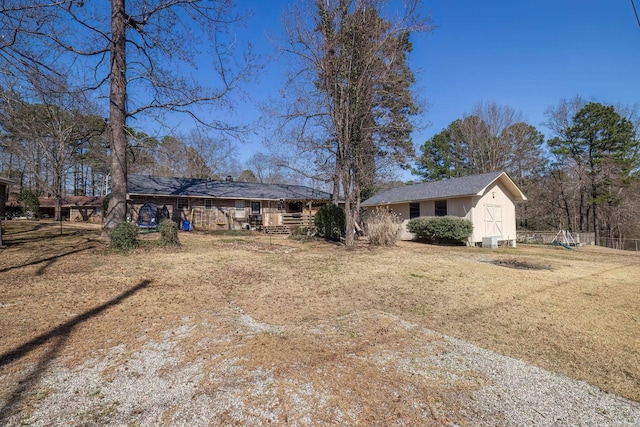 view of front of house featuring an outbuilding, a front lawn, and a storage unit