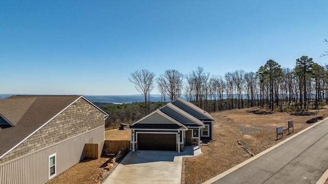 view of front of home with driveway, an attached garage, and fence