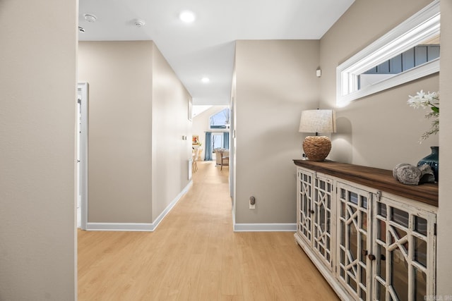 corridor with baseboards, wood finished floors, and recessed lighting