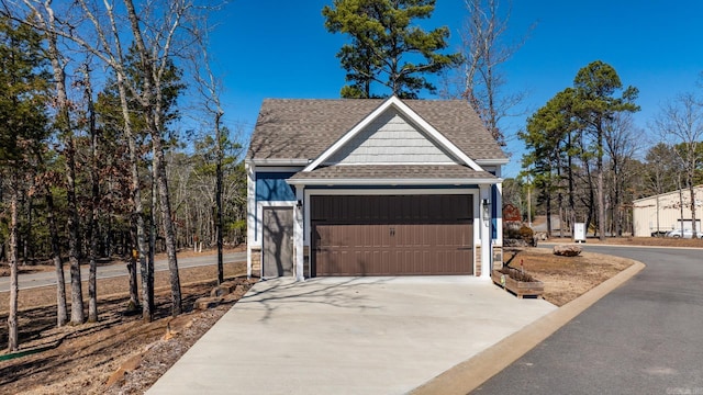 exterior space featuring a shingled roof, concrete driveway, and an attached garage