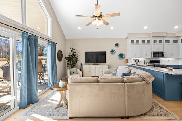 living area featuring lofted ceiling, light wood-style flooring, ceiling fan, and recessed lighting