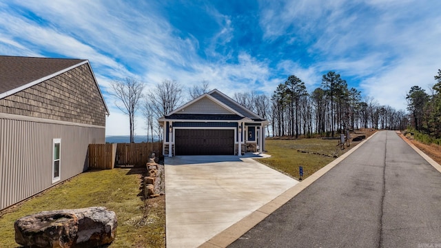 exterior space with a garage, driveway, a lawn, and fence