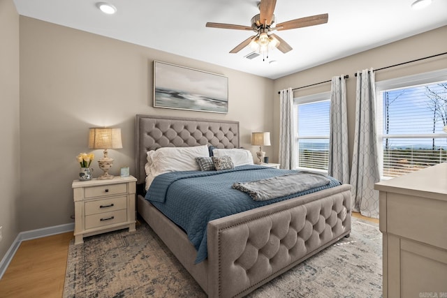 bedroom with a ceiling fan, light wood-style flooring, and baseboards