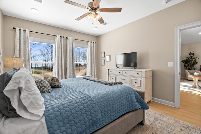 bedroom featuring light wood finished floors, ceiling fan, and baseboards