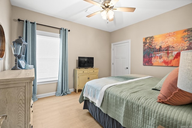 bedroom featuring light wood-style floors, ceiling fan, and baseboards