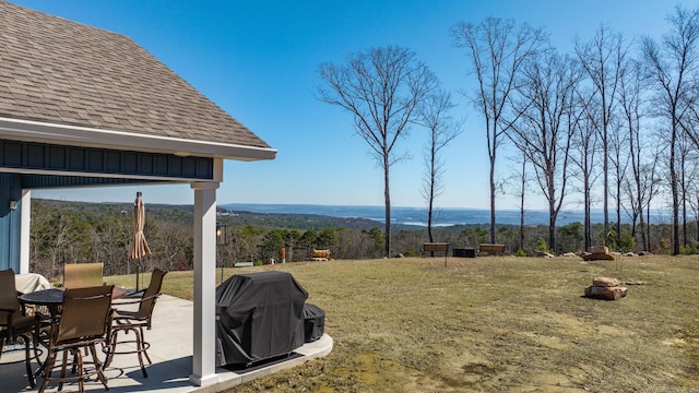 view of yard featuring a patio area and a view of trees