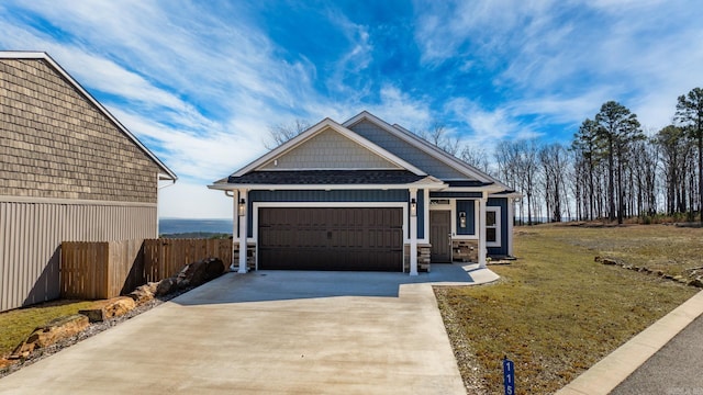 view of front facade with driveway, an attached garage, fence, and a front yard