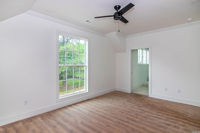 empty room featuring wood finished floors, visible vents, baseboards, a ceiling fan, and crown molding