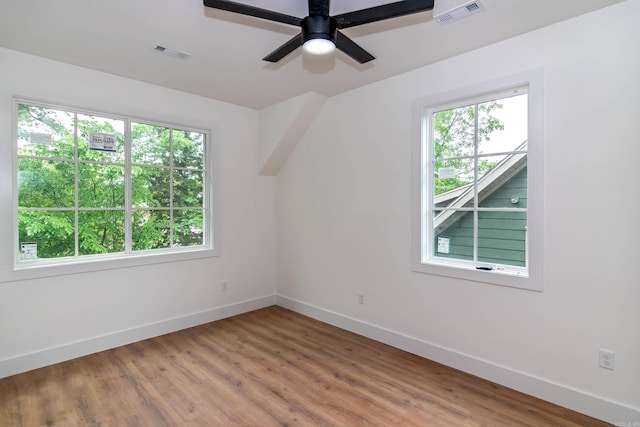 empty room featuring light wood-style flooring, visible vents, and baseboards