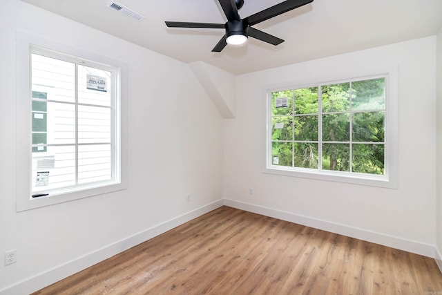 spare room with visible vents, ceiling fan, light wood-style flooring, and baseboards