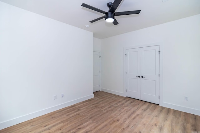 unfurnished bedroom with ceiling fan, a closet, baseboards, and wood finished floors