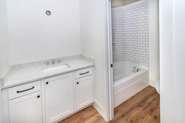 full bathroom featuring washtub / shower combination, vanity, toilet, and wood finished floors