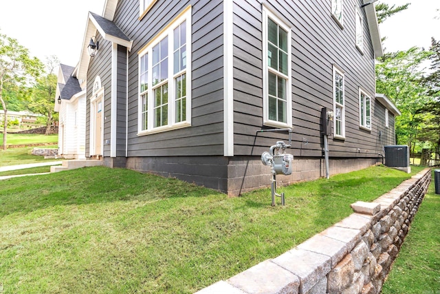 view of property exterior featuring a lawn and cooling unit