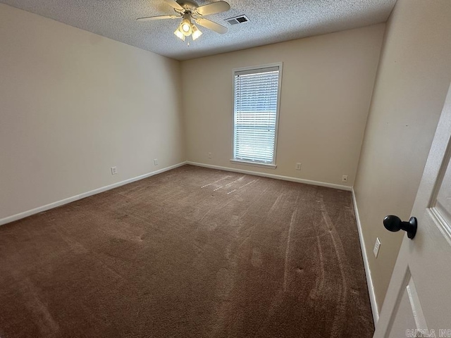 carpeted empty room with a ceiling fan, visible vents, a textured ceiling, and baseboards