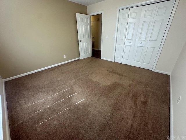 unfurnished bedroom with carpet floors, a closet, and baseboards