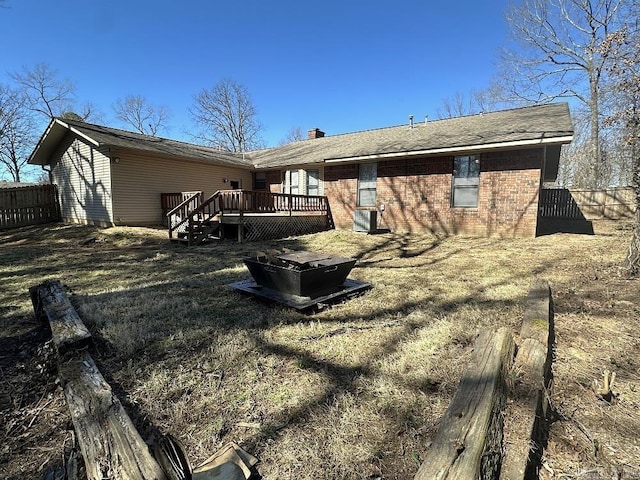 back of property with brick siding, central air condition unit, a wooden deck, and fence