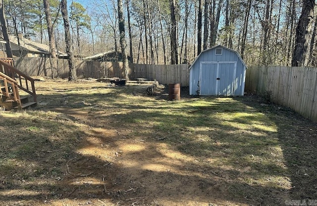 view of yard with an outbuilding, a storage unit, and a fenced backyard