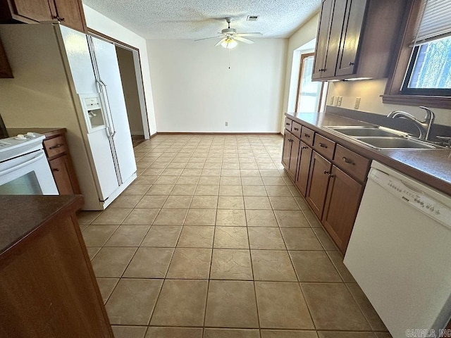 kitchen with white appliances, light tile patterned floors, a ceiling fan, a textured ceiling, and a sink