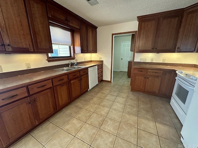 kitchen featuring light tile patterned floors, visible vents, a sink, a textured ceiling, and white appliances