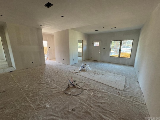 unfurnished living room with visible vents