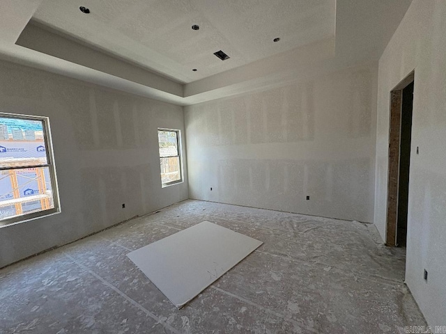 spare room with a raised ceiling and visible vents