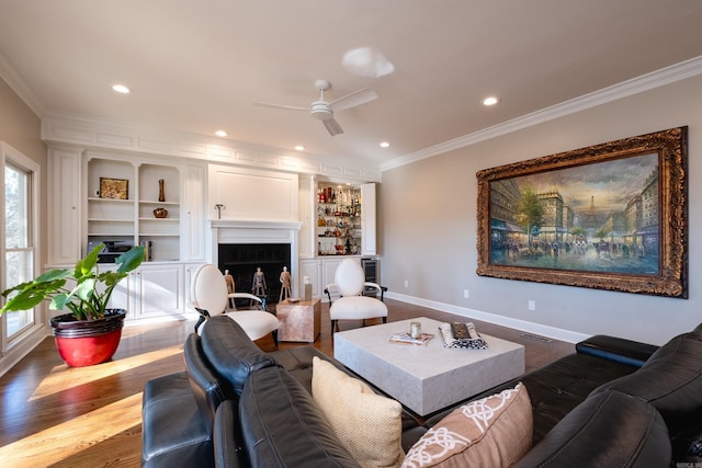 living area with dark wood-type flooring, a fireplace, crown molding, and baseboards