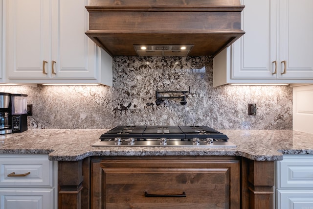 kitchen featuring premium range hood, decorative backsplash, and stainless steel gas stovetop