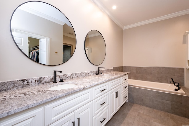 bathroom with double vanity, a garden tub, ornamental molding, and a sink