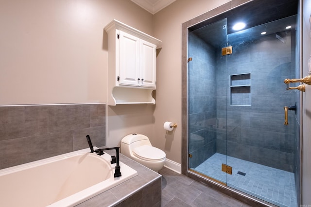 bathroom featuring toilet, a stall shower, a bath, baseboards, and tile patterned floors