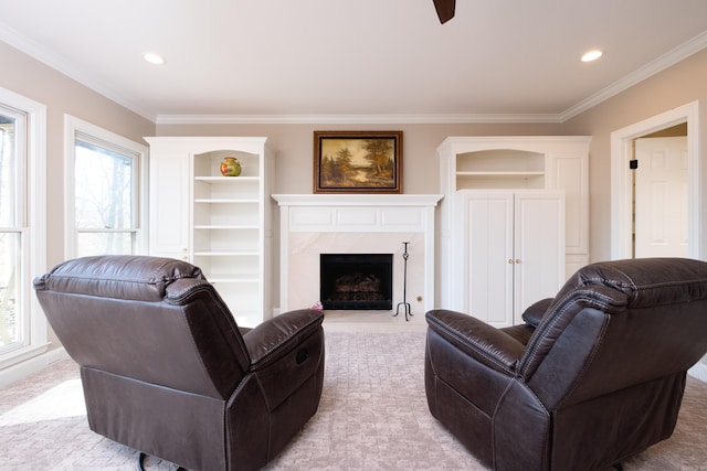 living room featuring ornamental molding, a premium fireplace, built in features, and a healthy amount of sunlight