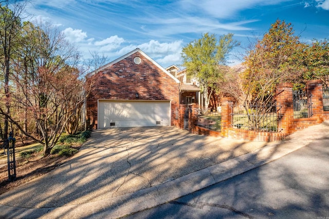 view of front facade featuring driveway, a gate, fence, and brick siding