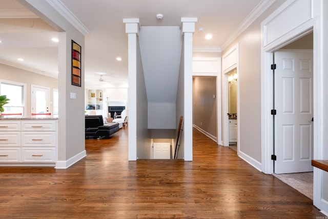 corridor featuring recessed lighting, ornamental molding, an upstairs landing, wood finished floors, and baseboards