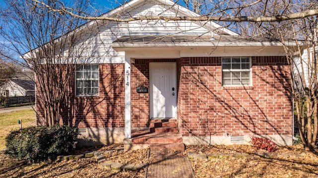 view of front of house featuring entry steps, crawl space, and brick siding