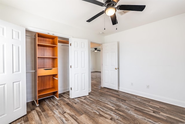 unfurnished bedroom featuring ceiling fan, visible vents, baseboards, a closet, and dark wood finished floors