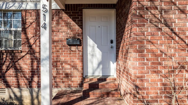 doorway to property with brick siding