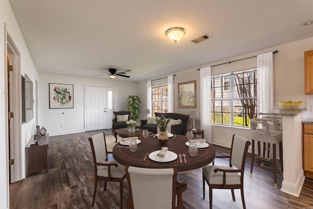 dining space featuring dark wood-style flooring, visible vents, ceiling fan, and baseboards