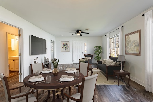 dining room featuring dark wood-style flooring, visible vents, ceiling fan, and baseboards